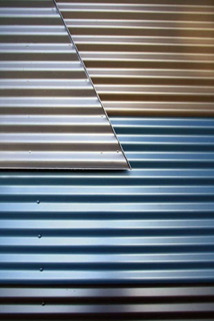 The wall features variously placed Stramit Corrugated panels made from COLORBOND® Metallic steel in the colours Citi®, Conservatory®, Cortex®, Facade® and Skybridge®.